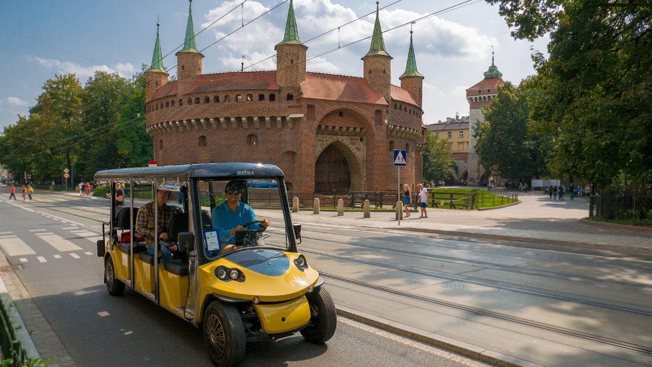 Toeristen genieten van een tour rond Krakau in een milieuvriendelijke melex.
